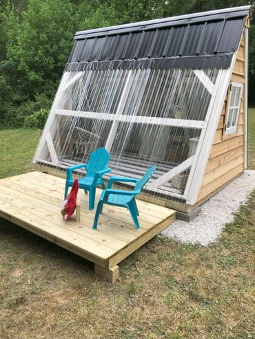 Outdoor A Frame playhouse with greenhouse panel wall that fully opens onto a deck