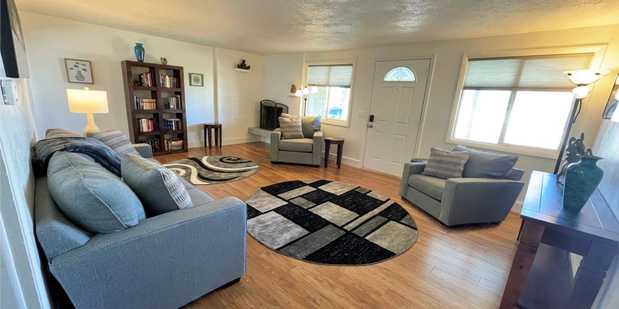 Cozy living room with modern gray furniture and decorative rugs.