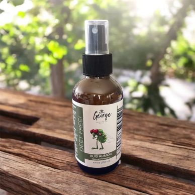 A spray bottle of King George Bug Armor natural protection on a wooden surface outdoors.