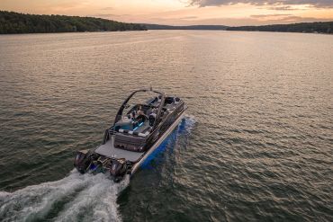Boat cruising on a lake during sunset.