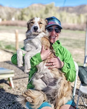 A white and tan border collie sitting on a girl's lap