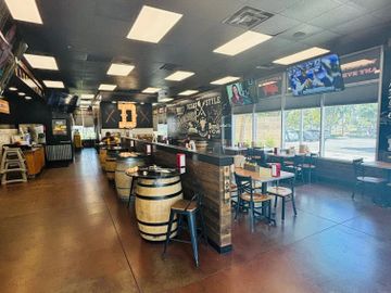 Interior of a modern rustic vibe our Texas-style barbecue restaurant provides barrel tables, plenty of seating, wall art, seven screens and plenty of fun. We feature and enjoy community events and fundraisers while providing smoked meats and catering services for any size event. At Dickeys Big or Small we do it all!