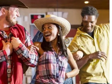 Group of friends dancing happily in a casual western-themed setting.