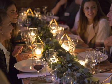 Elegant dinner party with candlelit table and guests engaged in conversation.