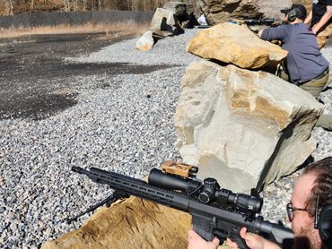 Students practice engaging steel targets from large rocks.