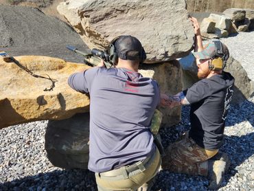 Instructors assists students while building positions to engage from in a mountainous environment.