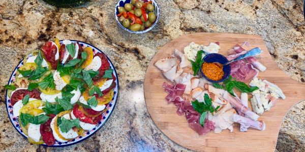 Caprese salad with fresh heirloom tomato, mozzarella, and balsamic glaze. Selection of custom meat and cheese.