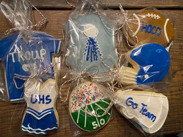 Packaged decorated cookies with football and cheerleading themes.