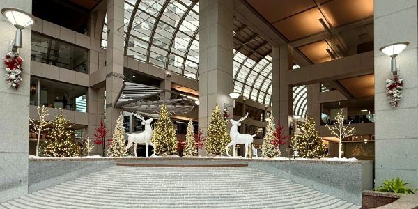Festive holiday decorations with white reindeer and Christmas trees.