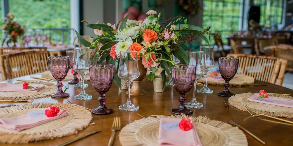 Elegant table setting with purple glasses and floral centerpiece.