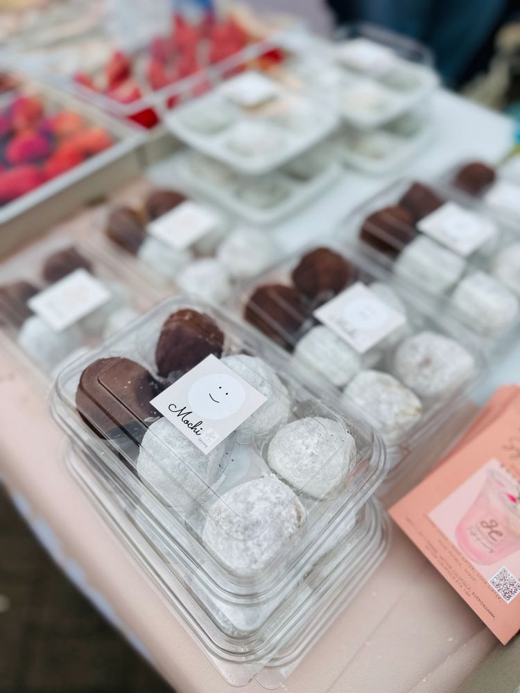 Clear plastic containers filled with powdered and chocolate mochi desserts.