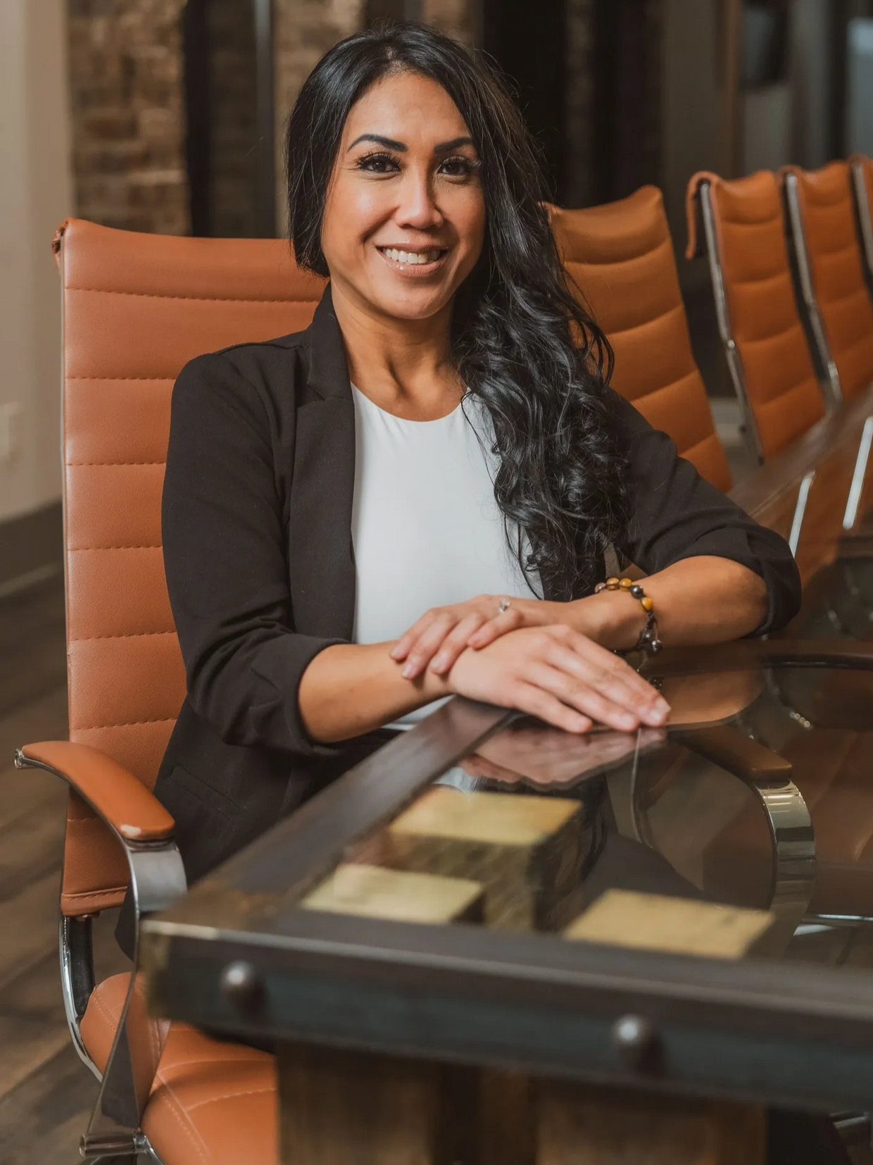 Confident professional woman smiling in a modern office meeting room.