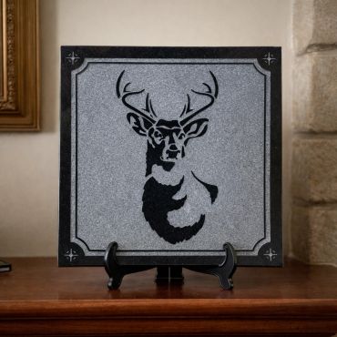 Black and gray deer silhouette plaque on stand.
