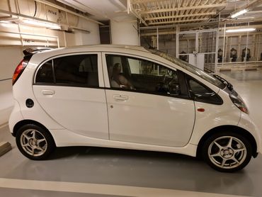 White compact hatchback car parked indoors.