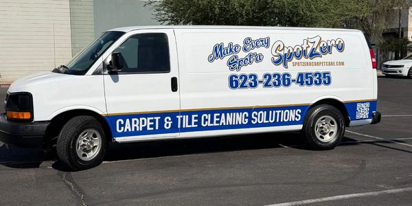 Camioneta con publicidad de limpieza de alfombras y azulejos.