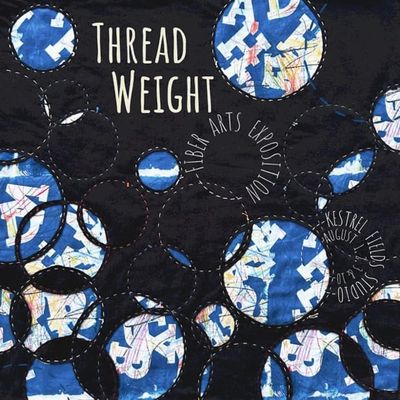 Textile art with blue and white circular patterns on black fabric.
