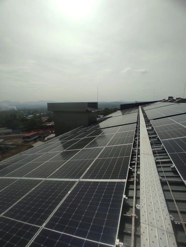 Solar panels installed on a rooftop under a bright sky.