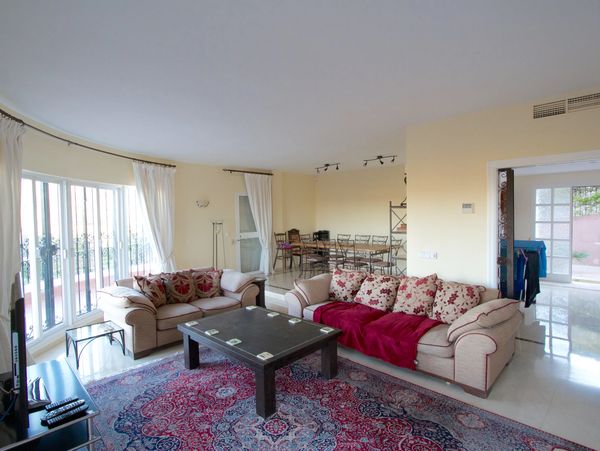A living room with two couches, a coffee table, a tv and a dining area