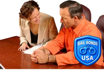 A man in handcuffs signs papers with a smiling woman at a bail bonds office.