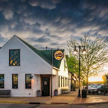 White building under dramatic mammatus clouds at sunset.