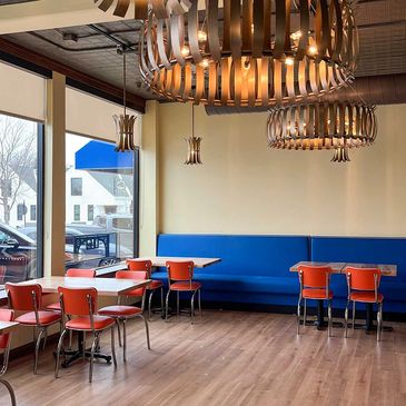 Modern dining area with red chairs and blue bench seating.
