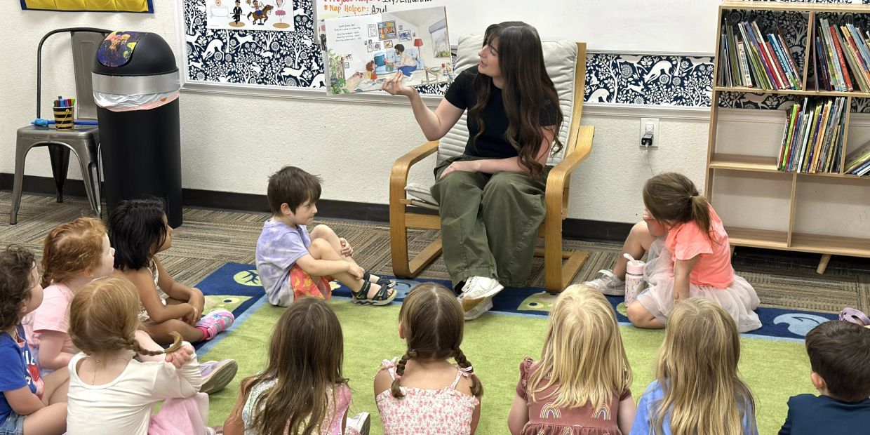 Woman reading a story to children in a classroom.
