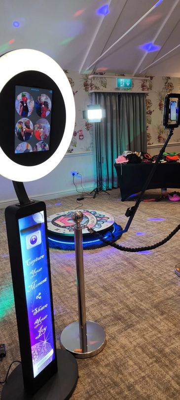 Modern photo booth setup with ring light and tablet screen showing photo options.