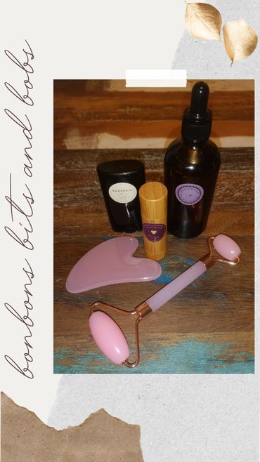 Handmade skincare bits and tools with a pink jade roller and gua sha.