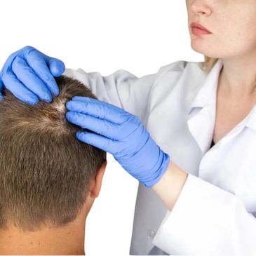 Doctor in gloves examining a patient's scalp closely.
