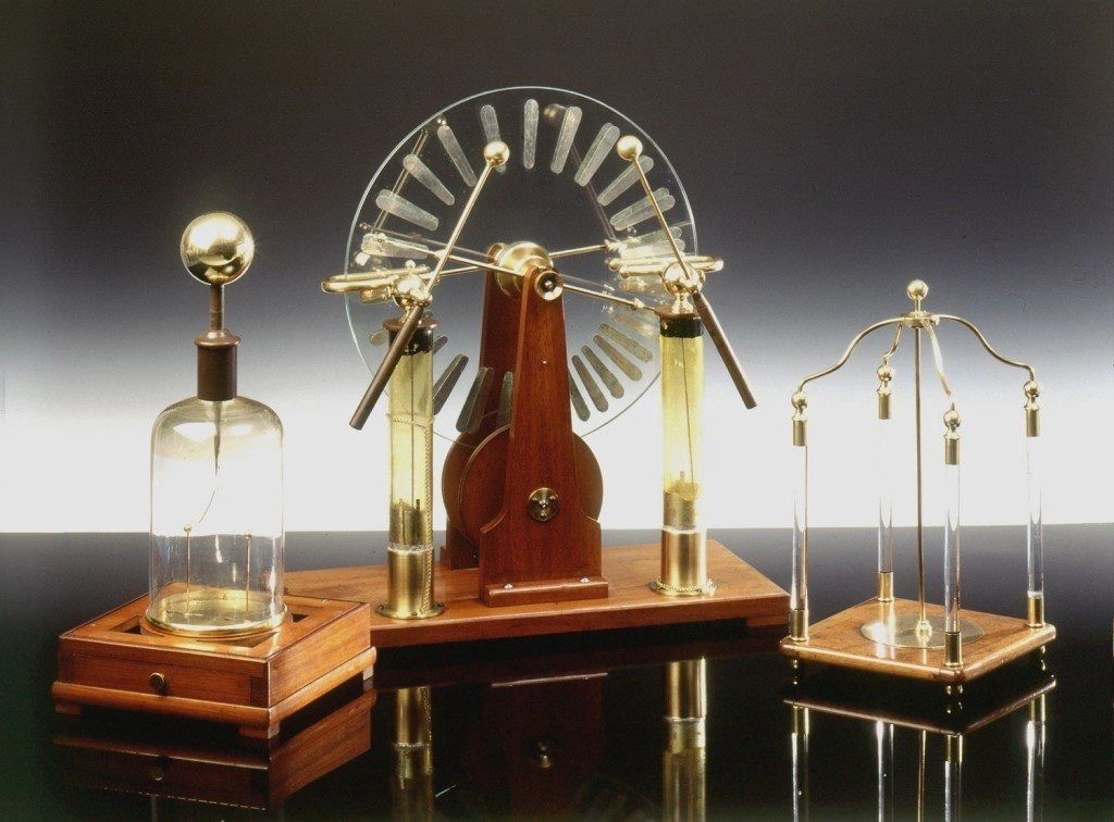 Vintage scientific apparatus with glass and brass components on wooden bases.