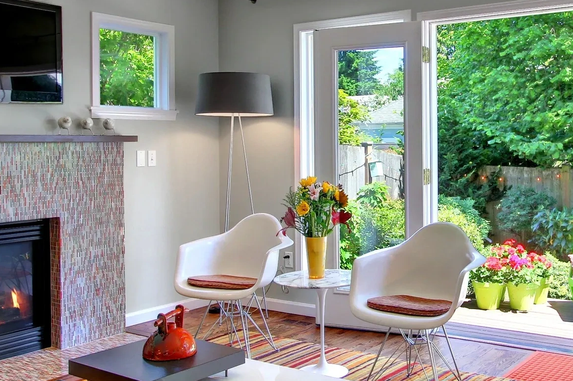 Colorful, modern living room with striped rug and tiled fireplace.