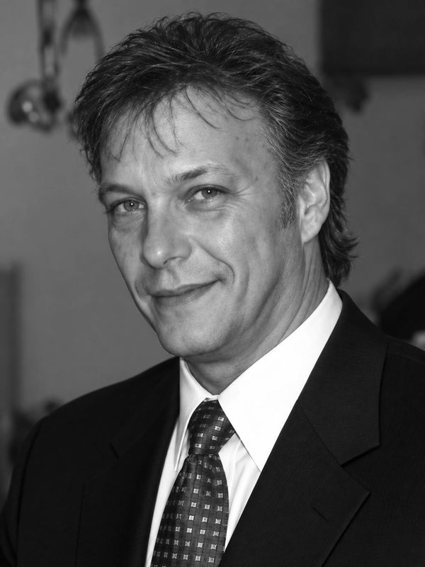 Smiling man in suit and tie.