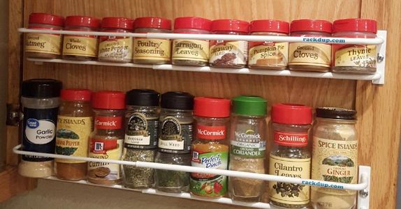Powder-coated white expandable spice racks installed on a cabinet door