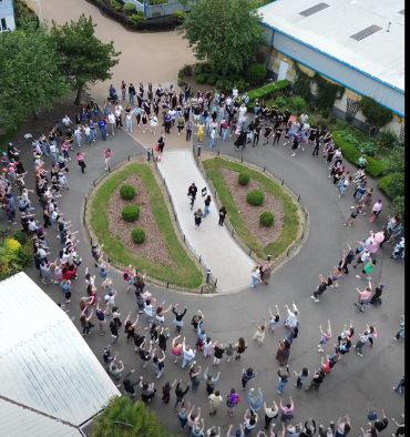 People forming a large circle outdoors.