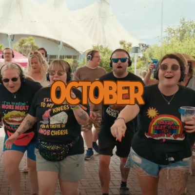 Group of people dancing outdoors with headphones, word OCTOBER overlaid.