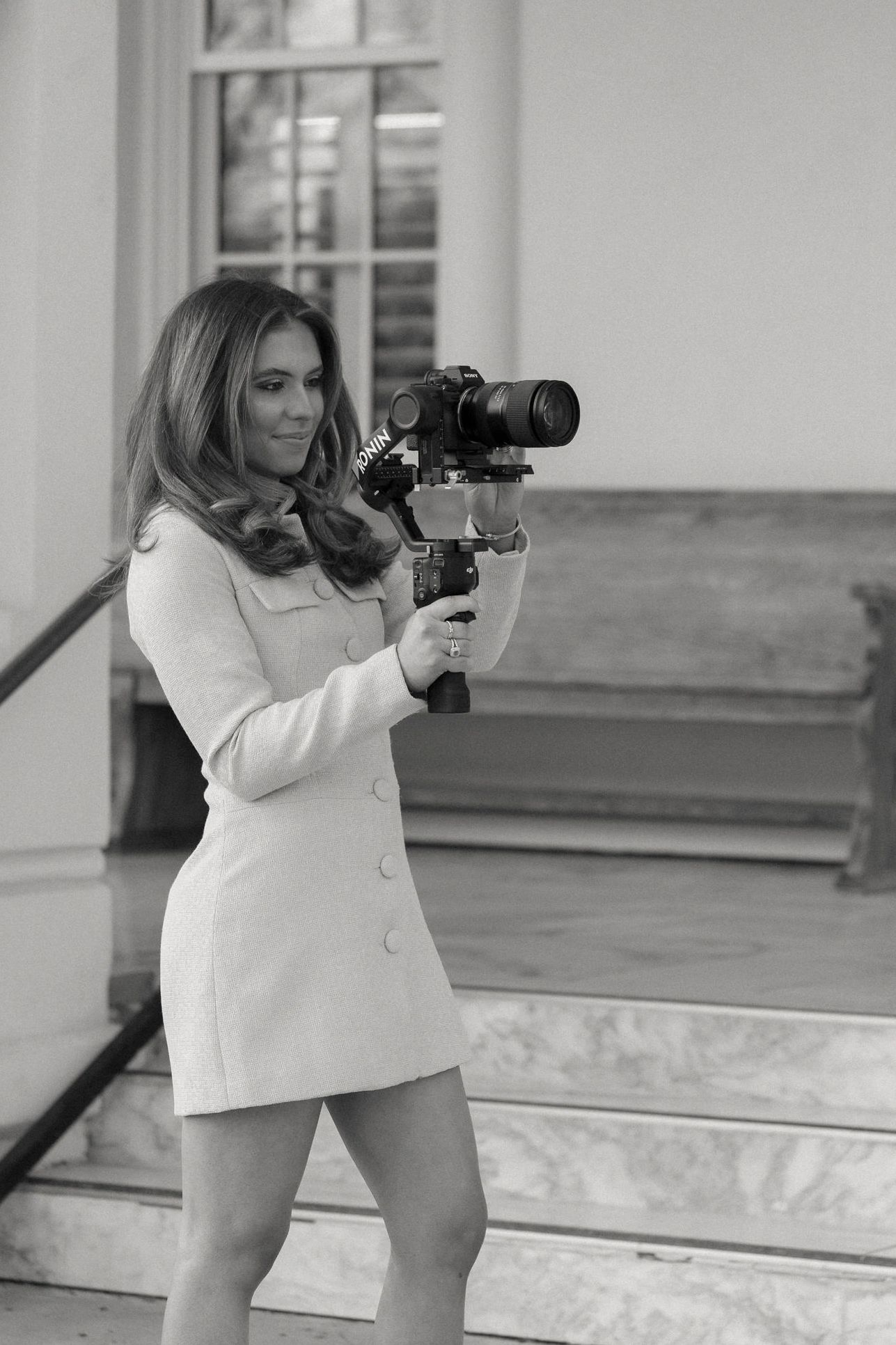 Woman filming with a professional camera stabilizer outdoors.