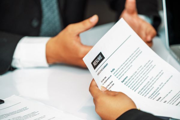 Person holding a resume during a professional meeting or interview.