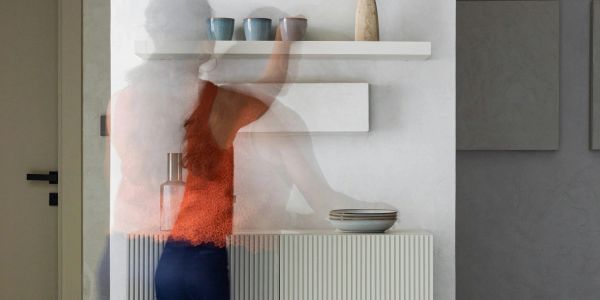 Blurred person reaching for items on a shelf.
