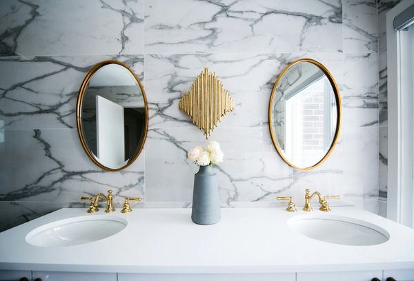 Two beautiful two faucet sinks located in a commercial bathroom.