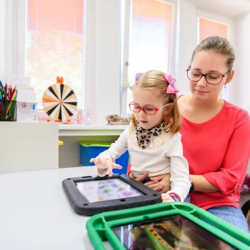 A woman and a girl using tablets.