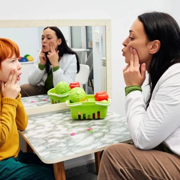 Speech therapist engaging a child in facial exercises.