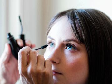 Woman having eyeliner applied.
