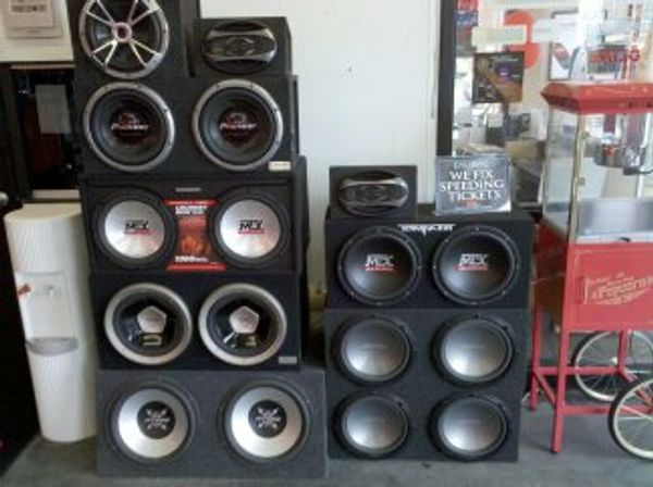 Stack of large subwoofers and speakers in a room.