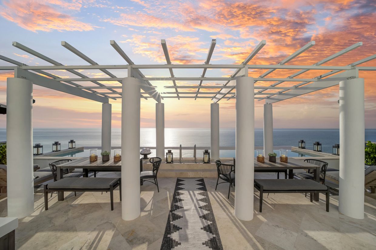 Elegant outdoor dining area with ocean view at sunset.