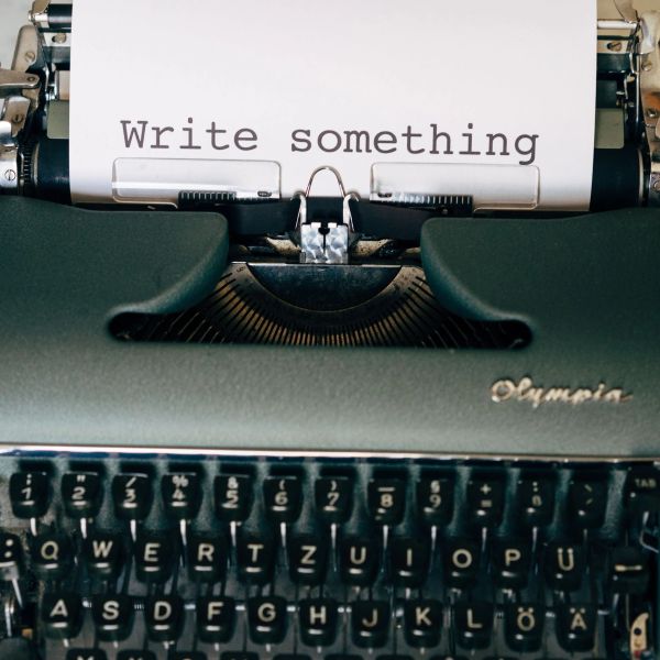 Vintage typewriter with a paper saying 'Write something'.