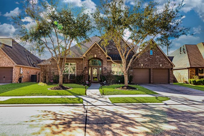 Curb view of home with blue skies, manicured lawn. This is an HDR photo image.