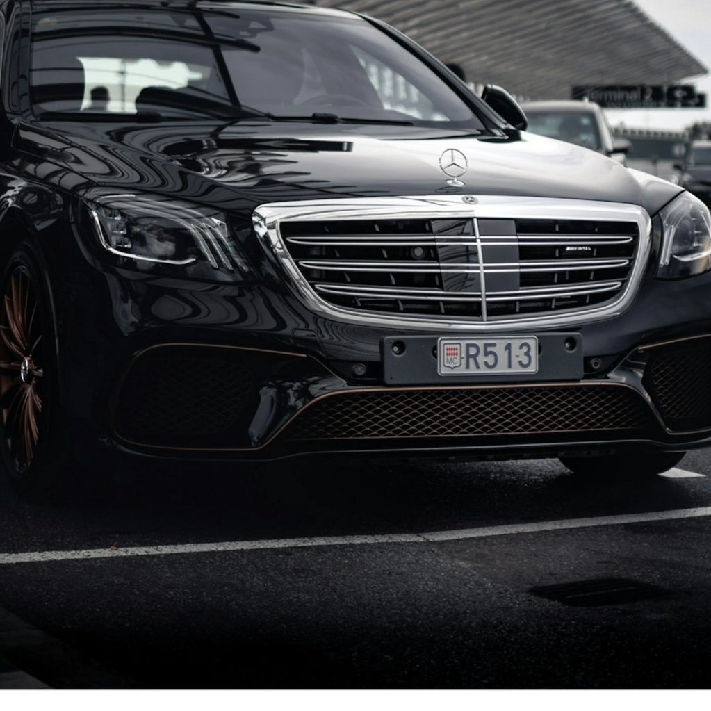 Black Mercedes parked outside Terminal 2 at an airport.