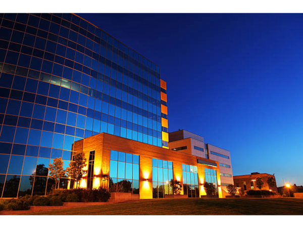 Modern office building with illuminated glass facade at dusk.