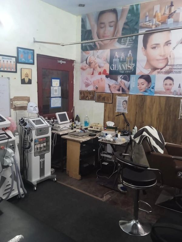 A skincare clinic room with advanced beauty machines and treatment posters.