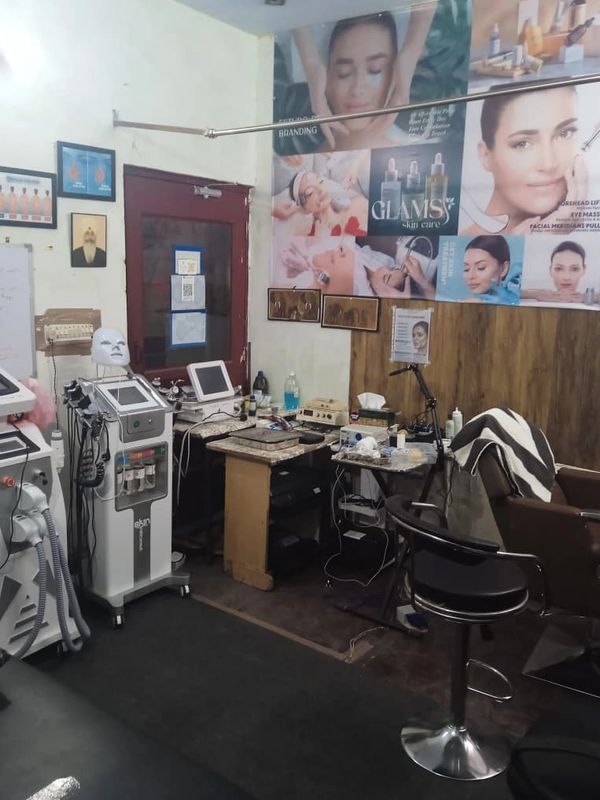 A skincare clinic room with advanced beauty machines and treatment posters.